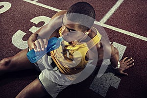 Young muscular build man drinking water of bottle