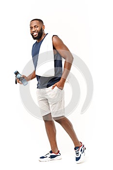 Young muscular build man hold bottle water after running, attractive athlete resting after workout outdoors, fitness and