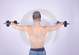 Young muscular fitness guy doing weights on black and white background