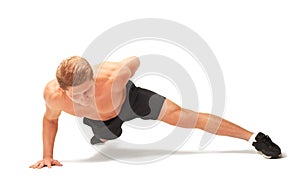 Young muscular handsome shirtless sportsman doing push-ups on one arm