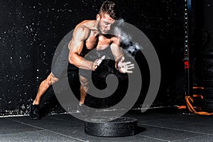 Young muscular man with big sweaty muscles doing push ups workout training with clap his hand above the barbell weight plate on th