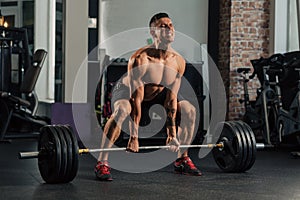 Young muscular man in the gym doing exercise