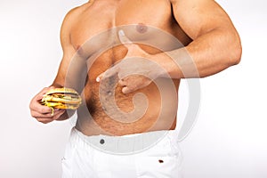 Young muscular man holding a hamburger