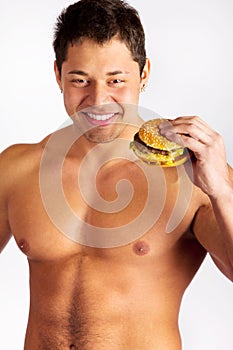 Young muscular man holding a hamburger