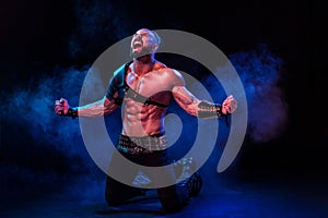 Young and muscular man performing a theatrical pose on stage.