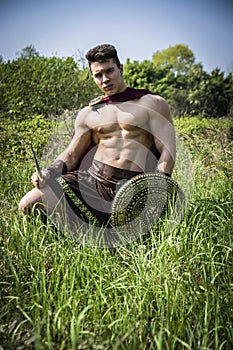 Young muscular man posing in gladiator costume