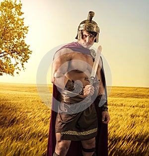 Young muscular man posing in gladiator costume