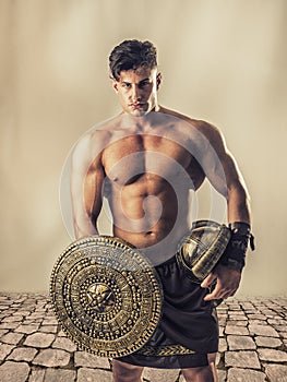 Young muscular man posing in gladiator costume