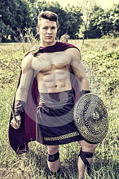 Young muscular man posing in gladiator costume