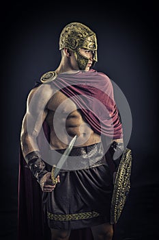 Young muscular man posing in gladiator costume