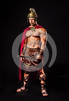 Young muscular man posing in roman gladiator costume