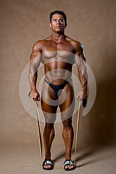 Young muscular man training with elastic band