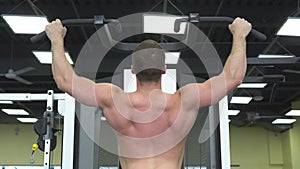 Young muscular man trains at the gym. Athlete of weight training