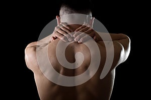 Young muscular sport man holding sore neck massaging cervical area suffering body pain