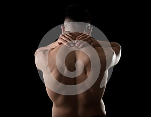 Young muscular sport man holding sore neck massaging cervical area suffering body pain