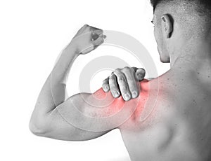 Young muscular sport man holding sore shoulder in pain touching massaging in workout stress