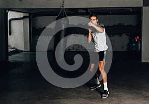 Young muscular sports guy practicing boxing