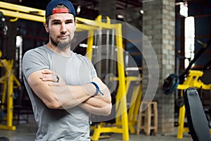 Young muscular trainer standing arm with sarcastic look photo