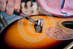 Young musician changing strings on a classical guitar in a guitar shop