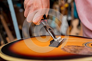 Young musician changing strings on a classical guitar in a guitar shop