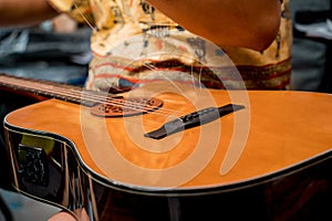 Young musician changing strings on a classical guitar in a guitar shop