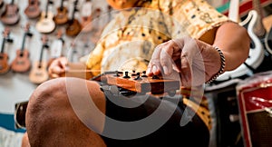 Young musician changing strings on a classical guitar in a guitar shop