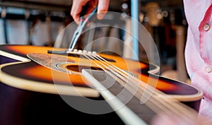 Young musician changing strings on a classical guitar in a guitar shop