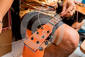 Young musician changing strings on a classical guitar in a guitar shop photo