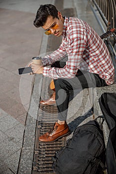 Young musician with coffee looking away outdoors