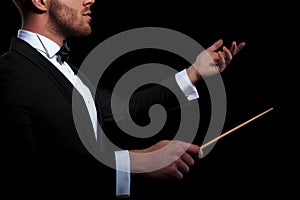 Young musician conducting using a stick and gesturing