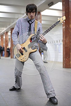 Young musician play on guitar at metro station