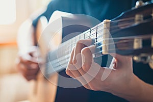 Young musician playing acoustic guitar