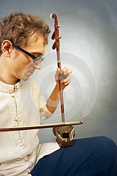 Young musician playing in erhu.