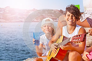 Young musician plays guitar at outing with friends