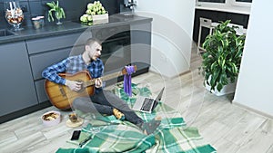 Young musician is singing and playing lyrical ballads on acoustic guitar. Male guitarist play guitar and singing romantic song. Ma