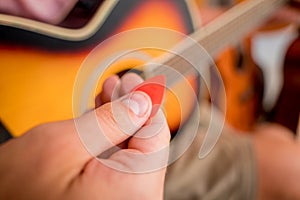 Young musician testing classical guitar in a guitar shop