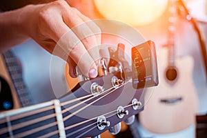 Young musician tuning a classical guitar in a guitar shop