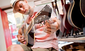 Young musician tuning a classical guitar in a guitar shop