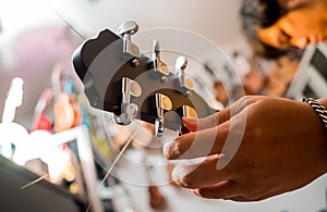 Young musician tuning a classical guitar in a guitar shop