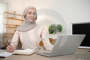 Young muslim business woman accountant working with financial document bills, calculate tax. Woman muslim freelancer