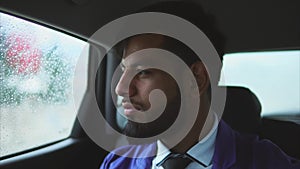 Young muslim businessman riding in the car on passenger`s seat.