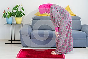 Young Muslim caucasian Female Praying Ruku at home.