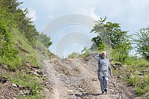 Young muslim girl wearing sport clothes walking alone on the rural mountain road