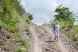 Young muslim girl wearing sport clothes walking alone on the rural mountain road