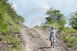 Young muslim girl wearing sport clothes walking alone on the rural mountain road