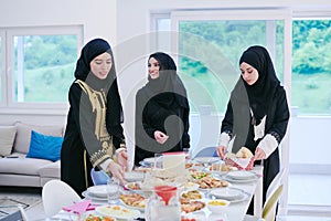 Young muslim girls serving food on the table for iftar dinner