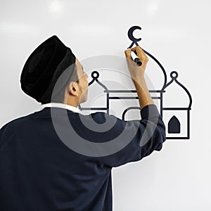 Young Muslim man drawing on a whiteboard