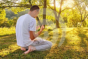 Young Muslim man pray in nature at sunset time