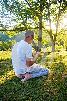 Young Muslim man pray in nature at sunset time