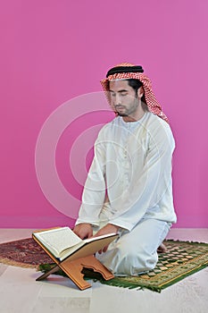 Young muslim man reading Quran during Ramadan